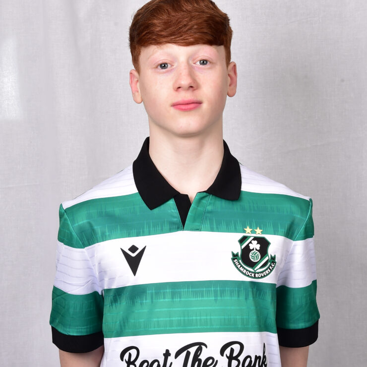 Young Shamrock Rovers player in green and white jersey, standing confidently.