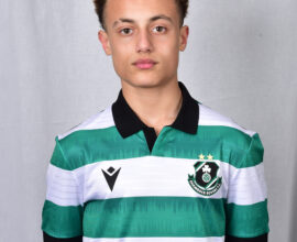 Young Shamrock Rovers player in green and white jersey, standing against a grey background.