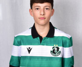 Young Shamrock Rovers player in green and white jersey, standing against a grey background.