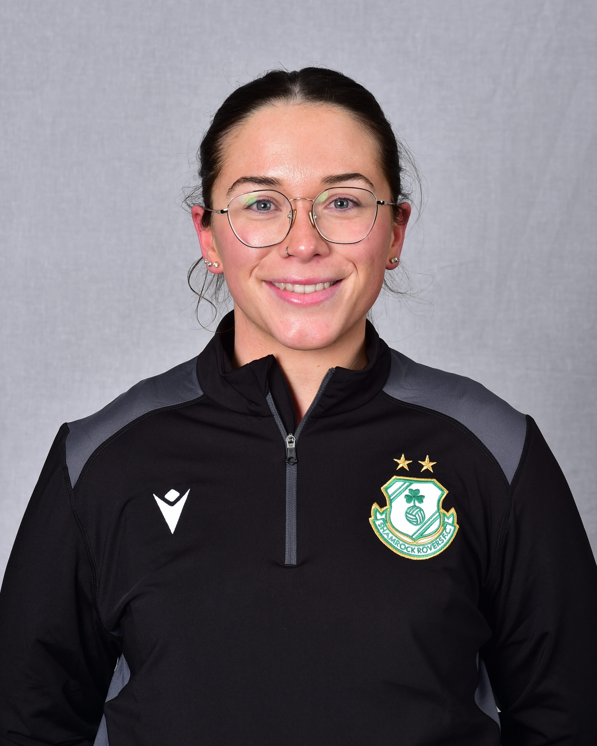 Female football player in Shamrock Rovers kit smiling at camera.