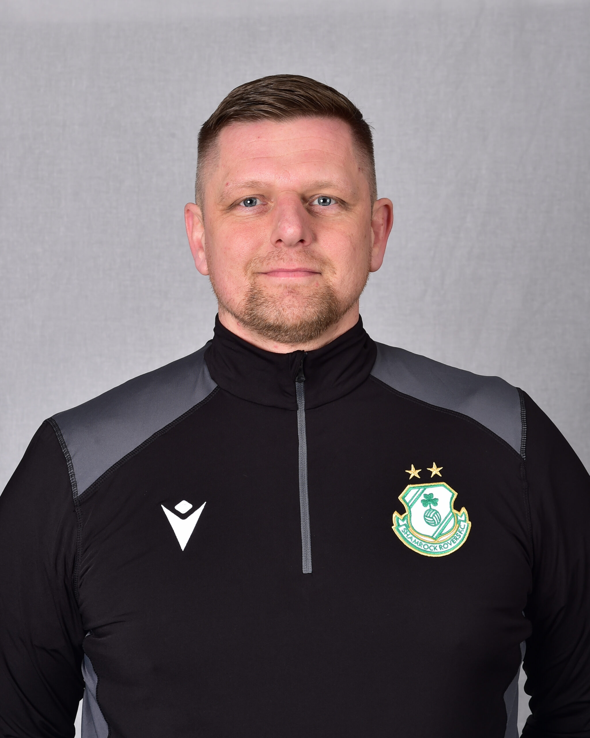 Shamrock Rovers coach in black team jacket with club crest.