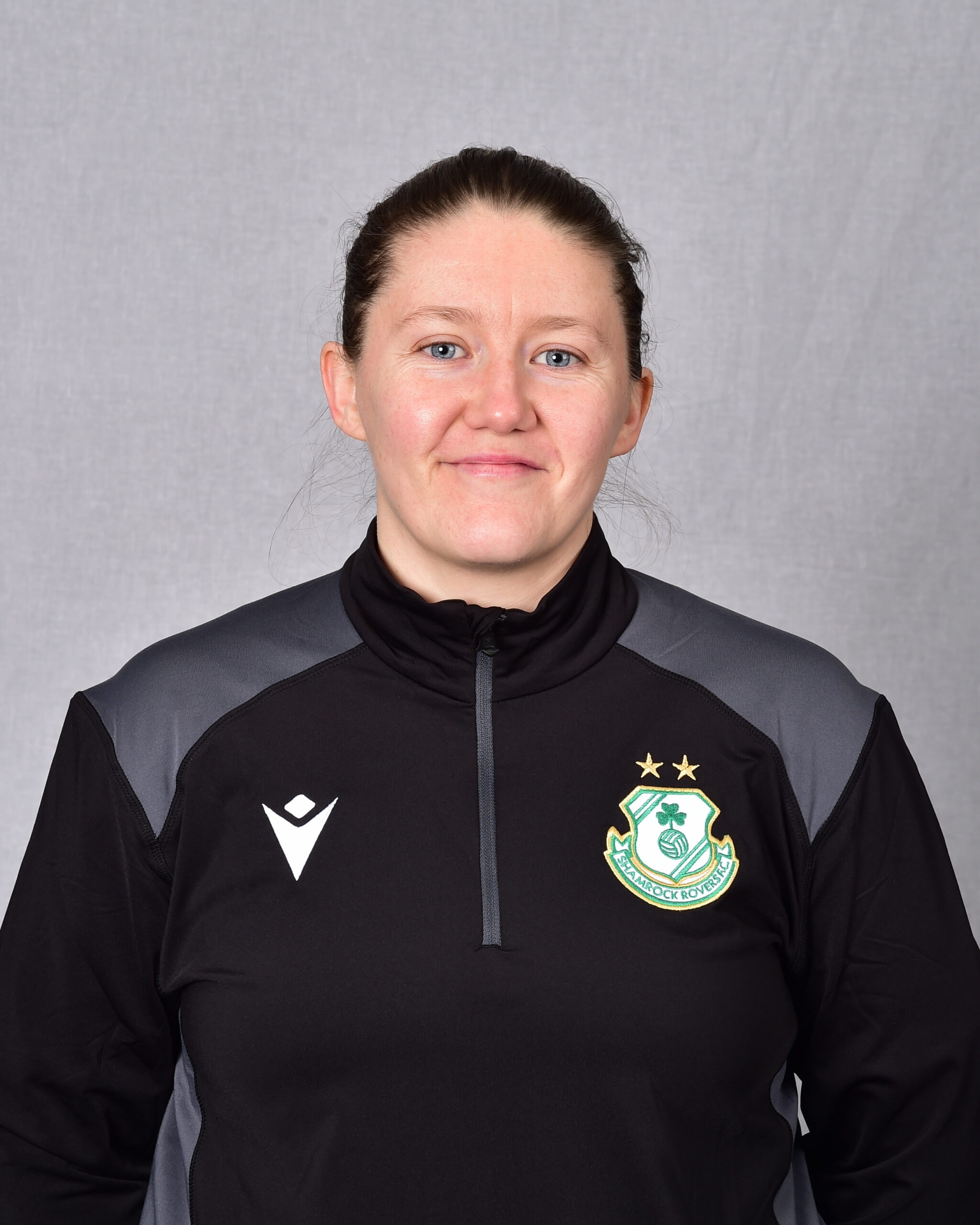 Female Shamrock Rovers player in team kit with club crest.