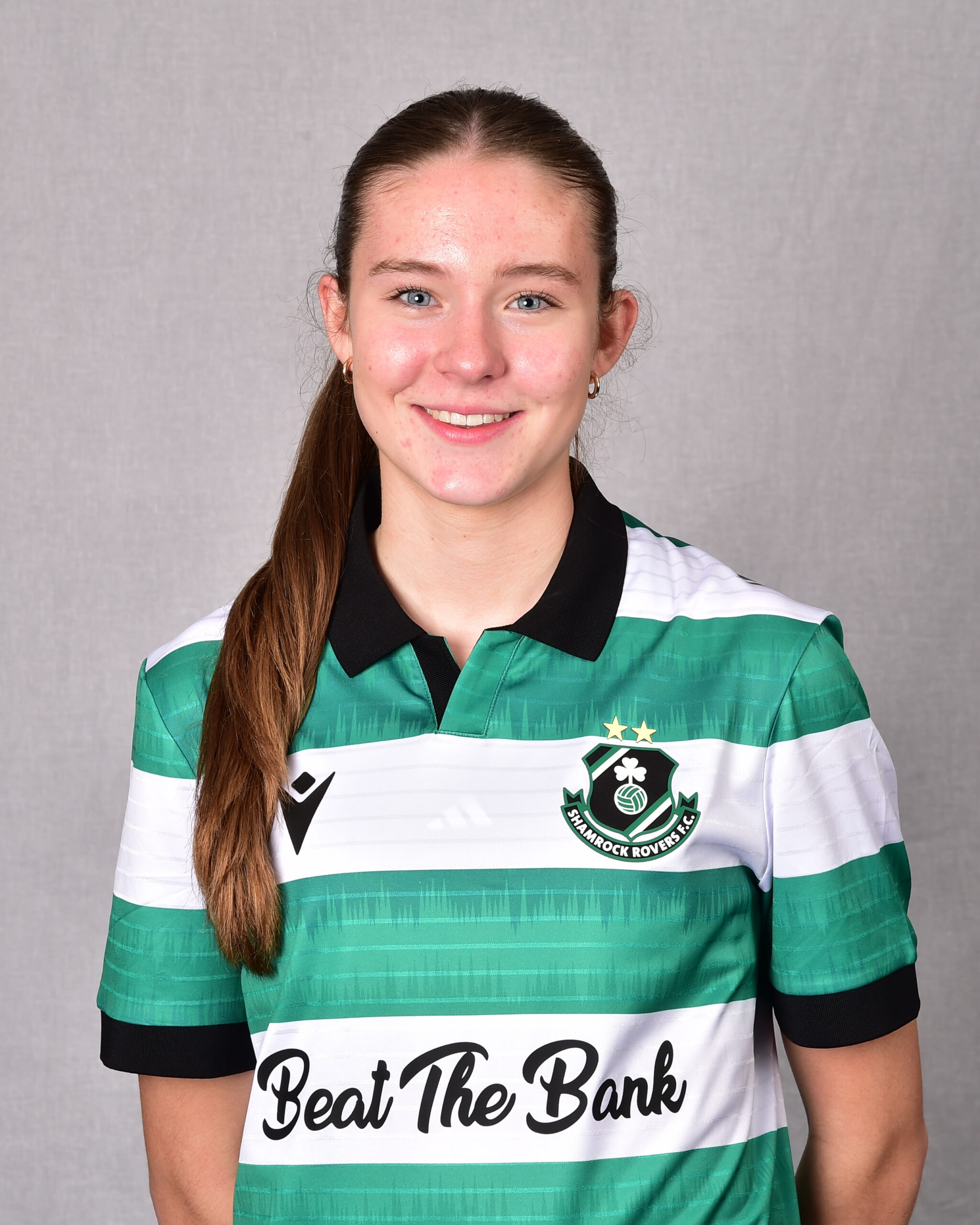 Shamrock Rovers female player in team jersey, smiling.