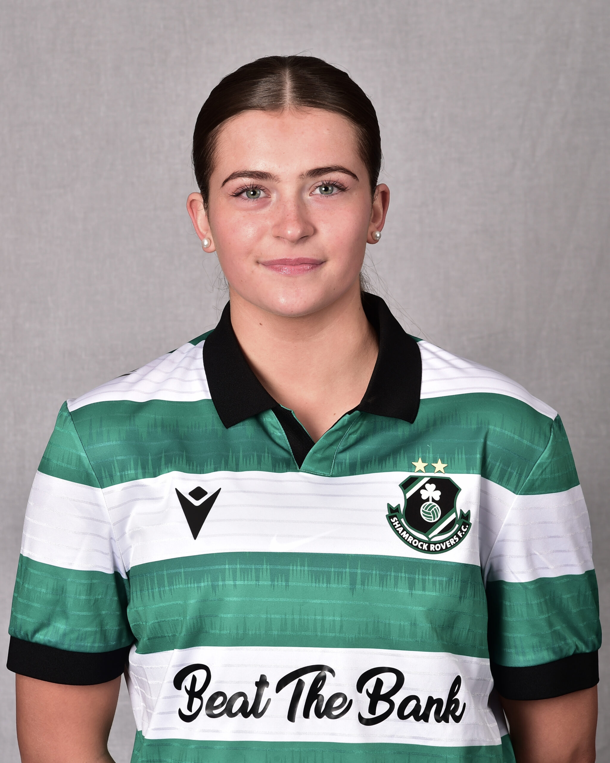 Female Shamrock Rovers player in green and white jersey, smiling confidently.