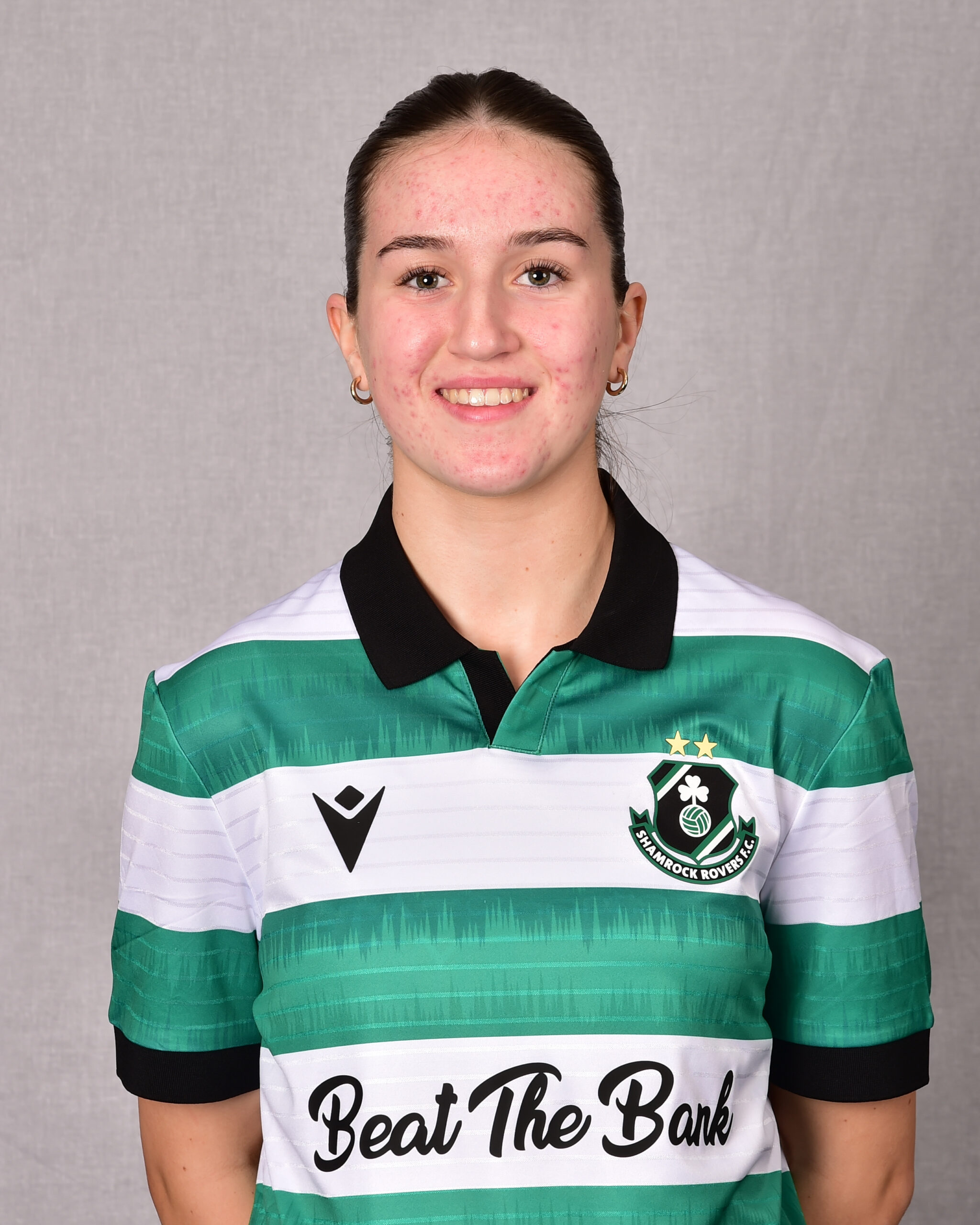 Female footballer in Shamrock Rovers kit smiling.