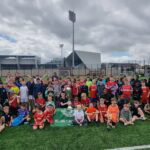 Shamrock Rovers players and children pose together on the football pitch.