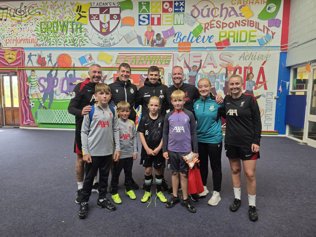 Shamrock Rovers players with Liverpool FC Foundation team in colourful mural background.