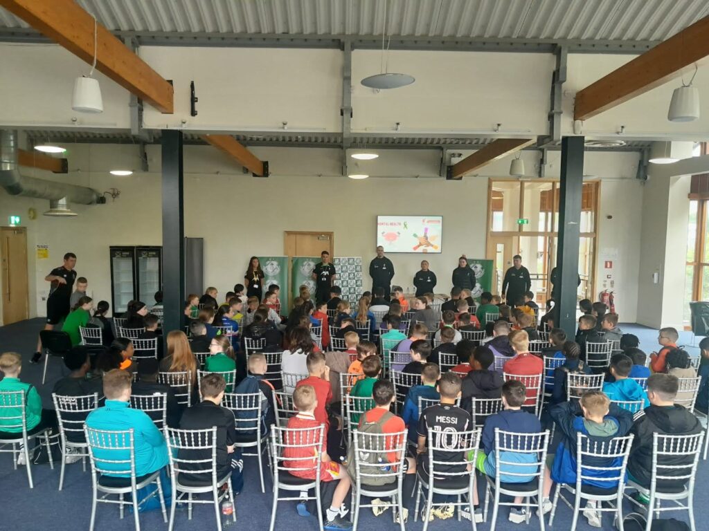 Shamrock Rovers team members with children at partnership event.