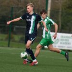 Two young footballers competing for the ball during a Shamrock Rovers youth match.