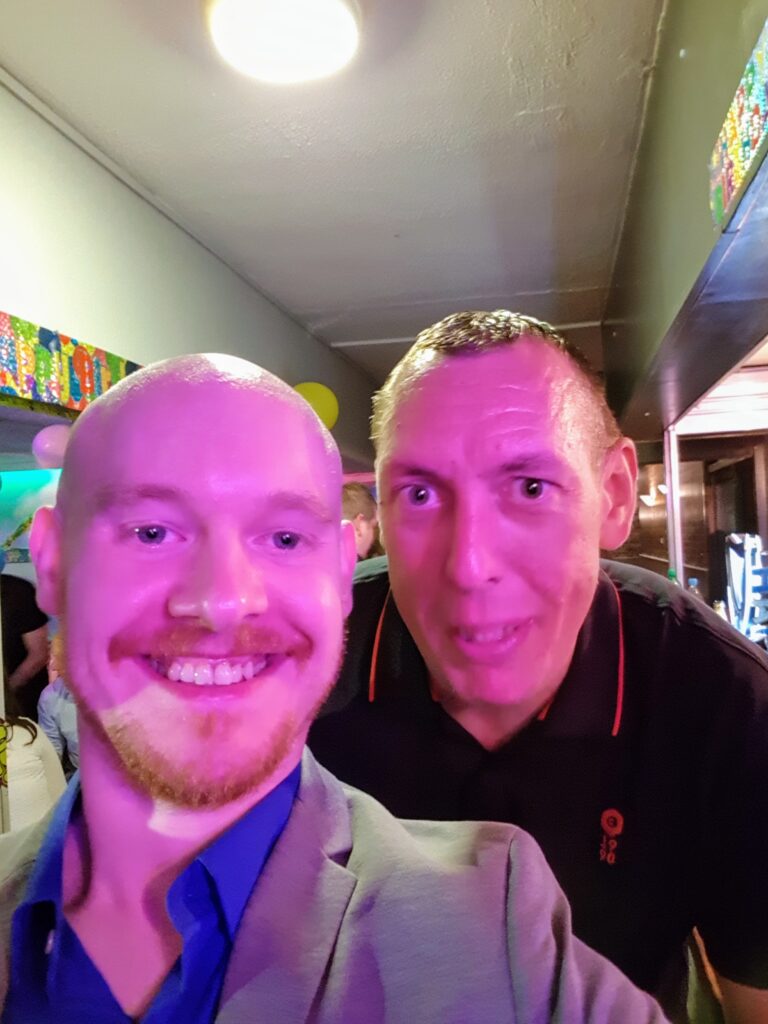 Two men smiling at a Shamrock Rovers event, celebrating together.