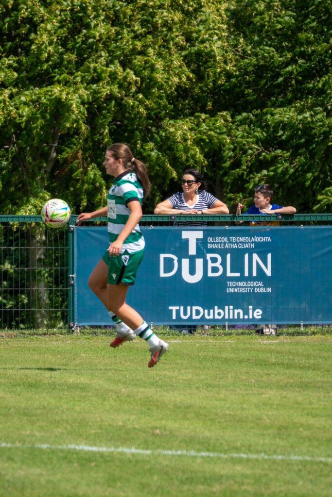 Shamrock Rovers woman footballer in green kit on the field during match.