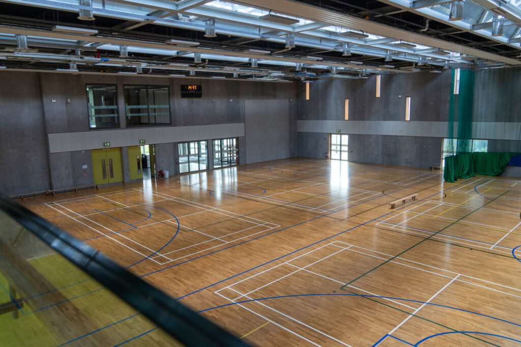 Indoor sports hall at TU Dublin Tallaght Campus with wooden flooring and sports markings.