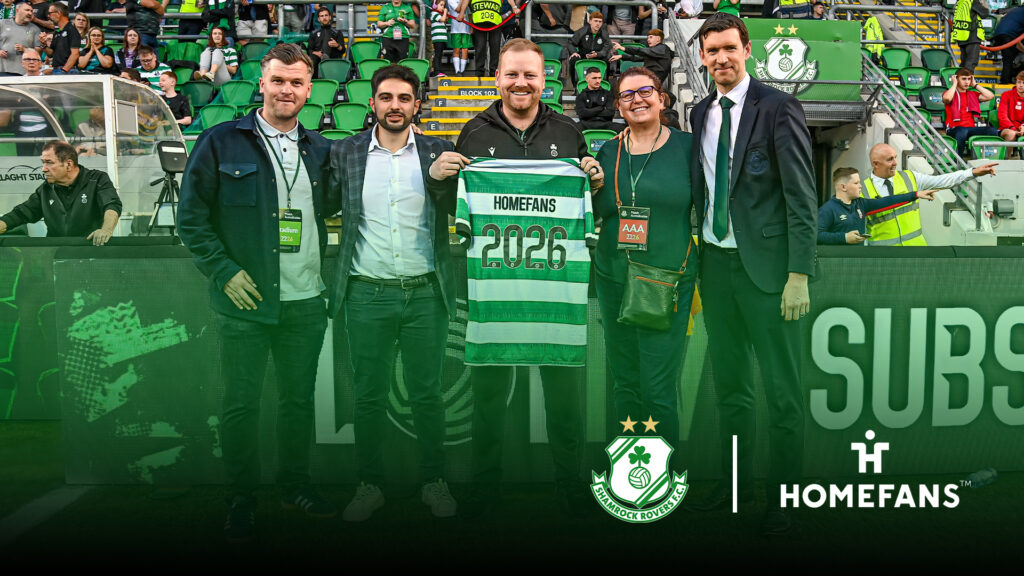 Group of five men at Shamrock Rovers stadium holding a 2026 Homefans jersey.